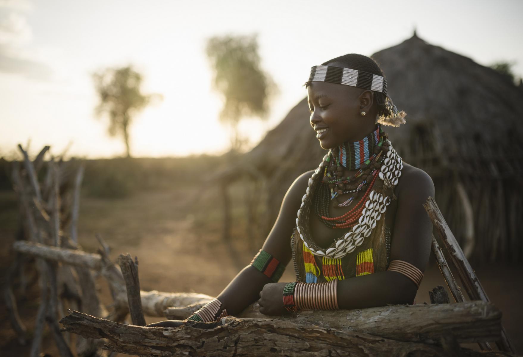 A tranquil moment as a young girl smiles with the golden hour sun setting behind her.